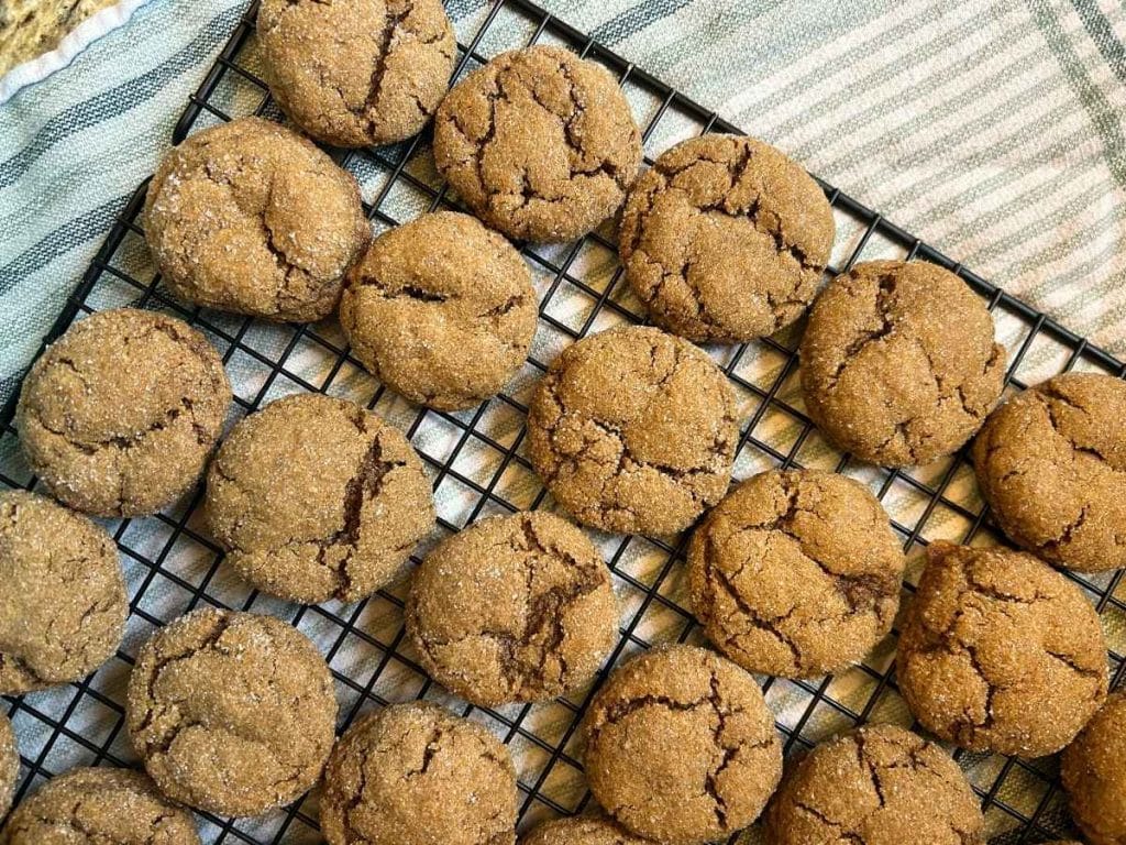 cooling rack full of baked molasses cookies