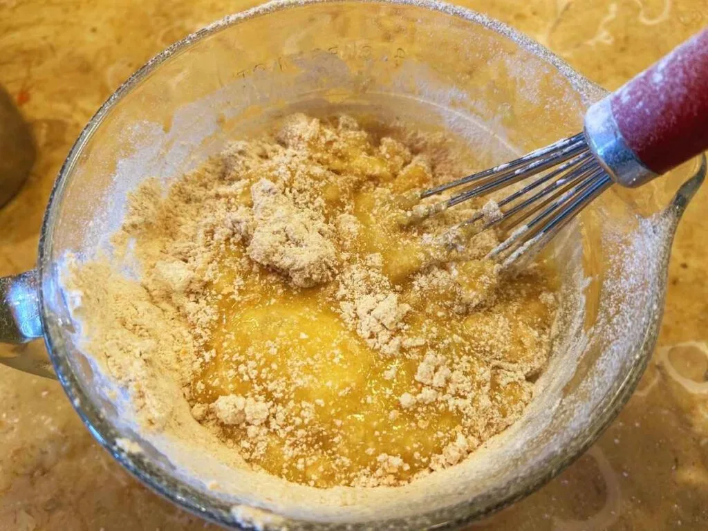 mixing flour into batter with a whisk