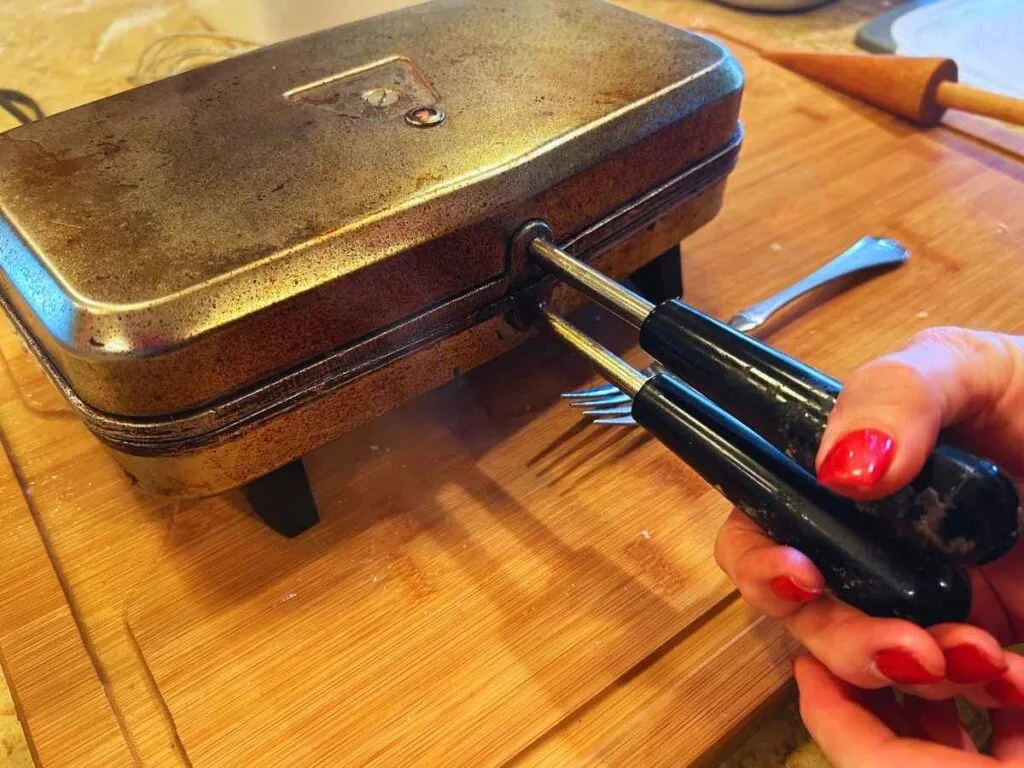 squeezing handles together on krumkake iron