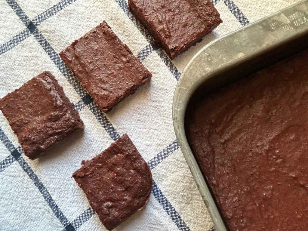 squares of beet brownies on a kitchen towel next to the pan