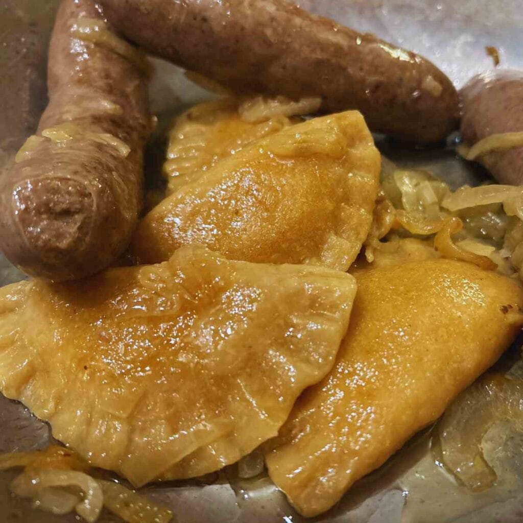 close up view of cooked pierogies with sausages