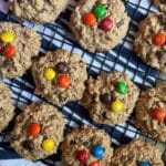 oatmeal chocolate chip cookies with m&ms on top cooling on a rack