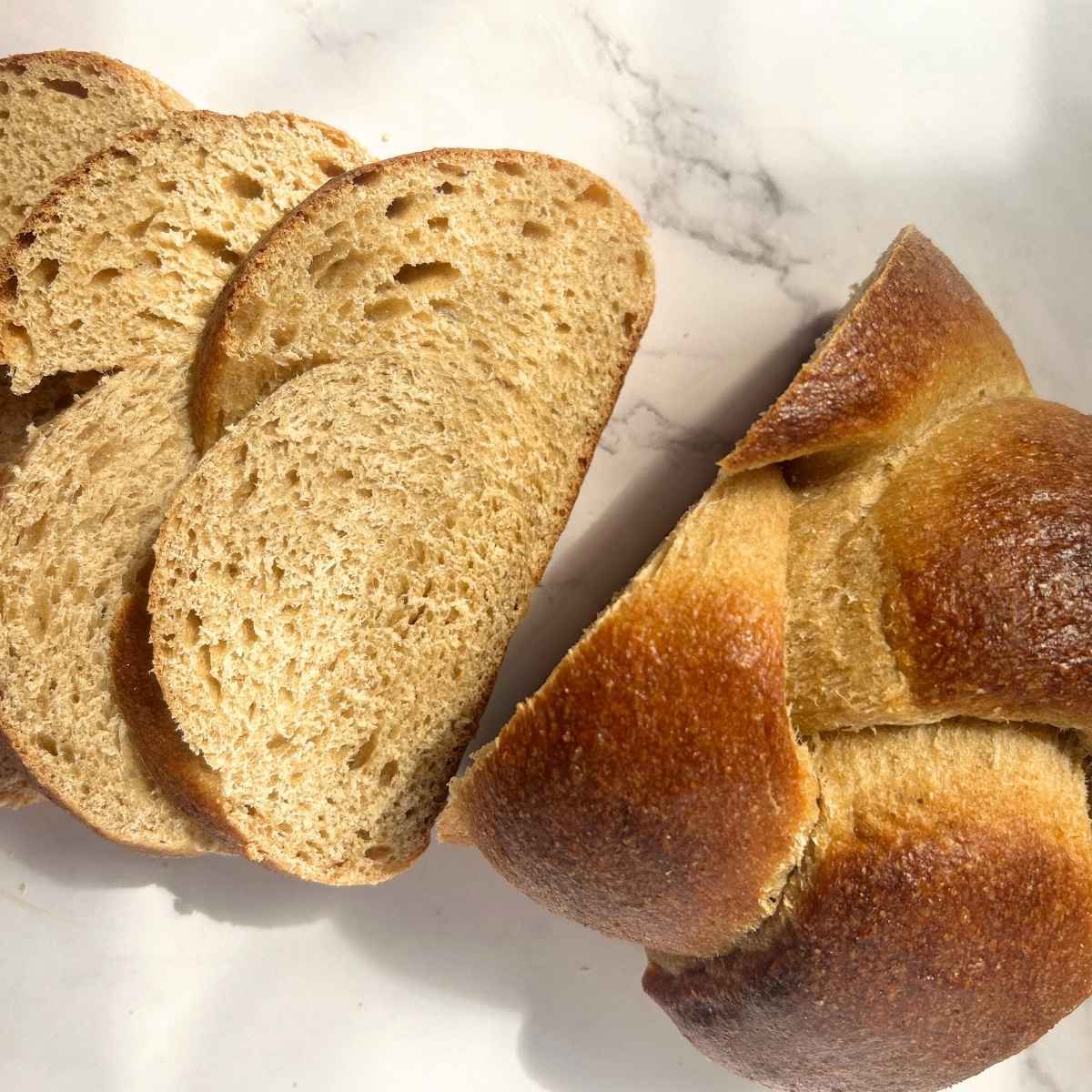 top view of a loaf of sourdough challah bread sliced up