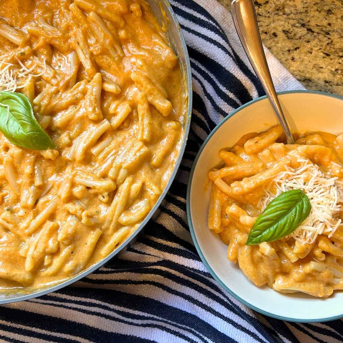 skillet and bowl full of pumpkin mac and cheese