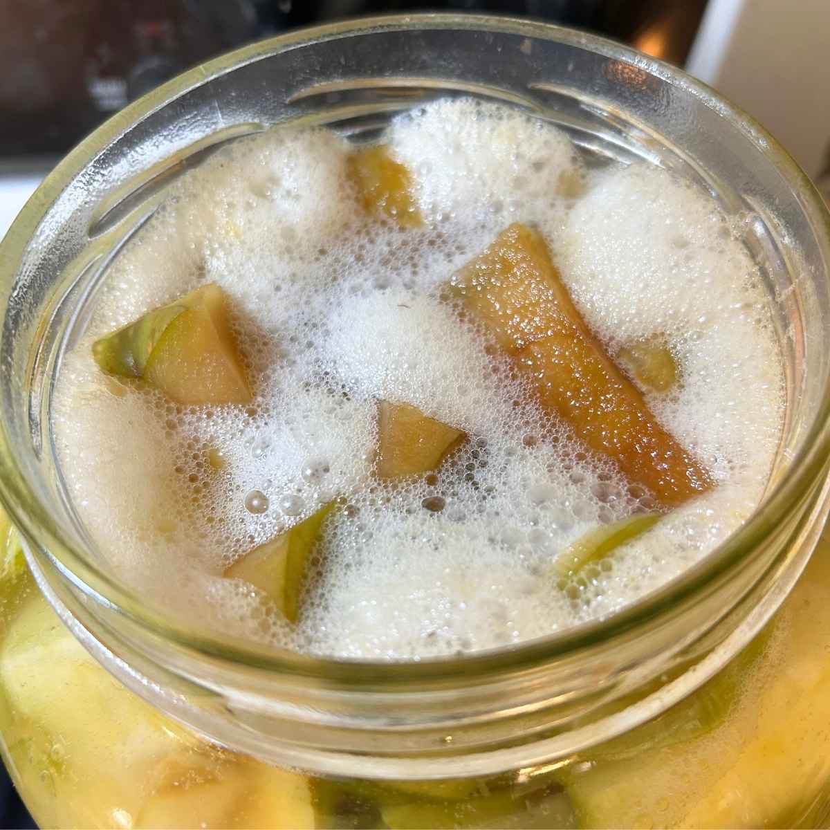 bubbly liquid with apple cores fermenting in a jar