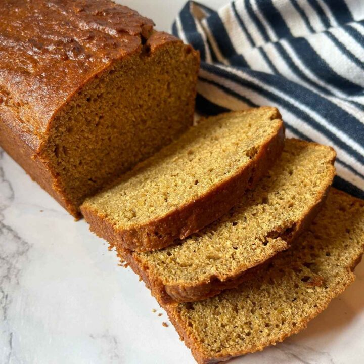 slices of sourdough discard pumpkin bread next to the rest of the loaf