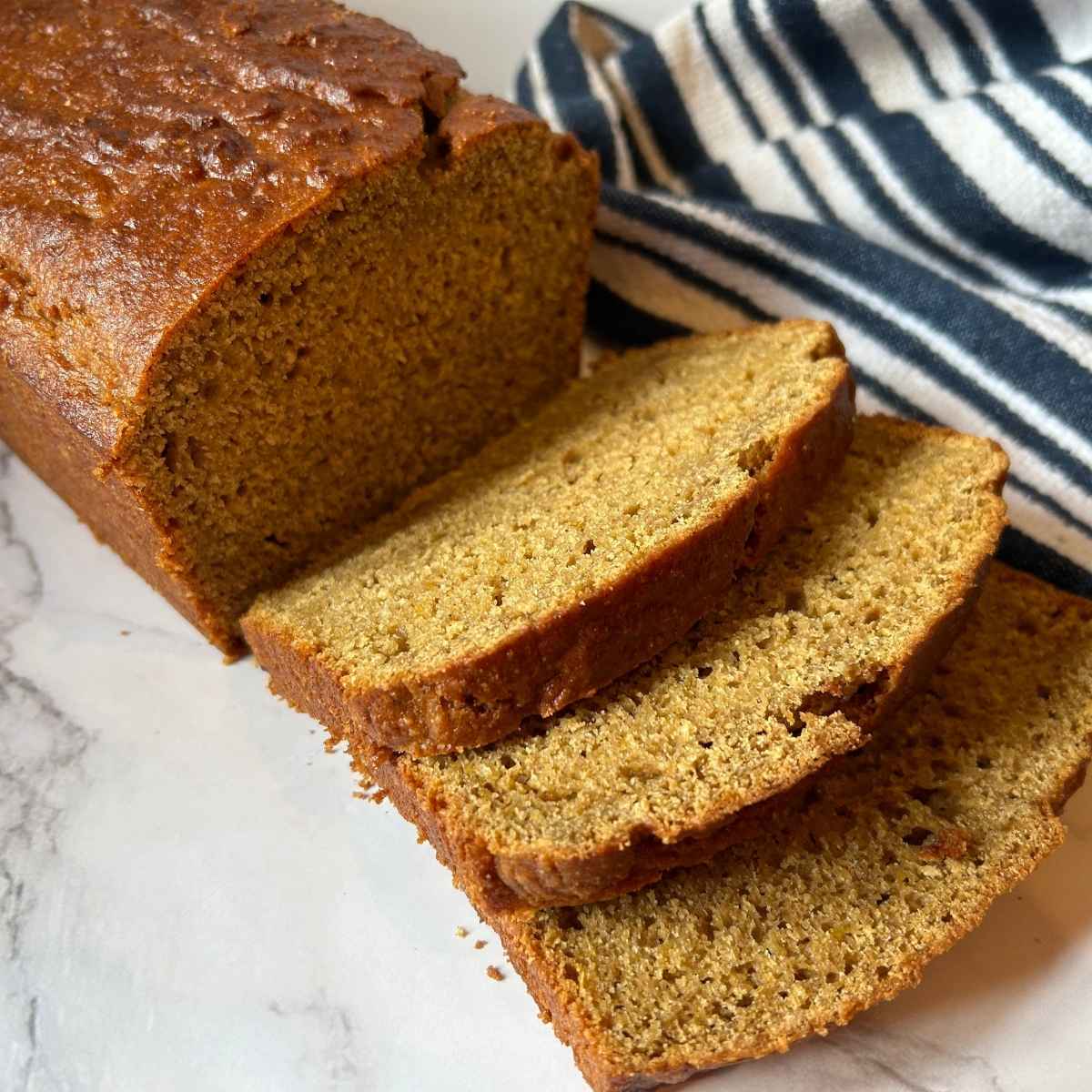 slices of sourdough discard pumpkin bread next to the rest of the loaf