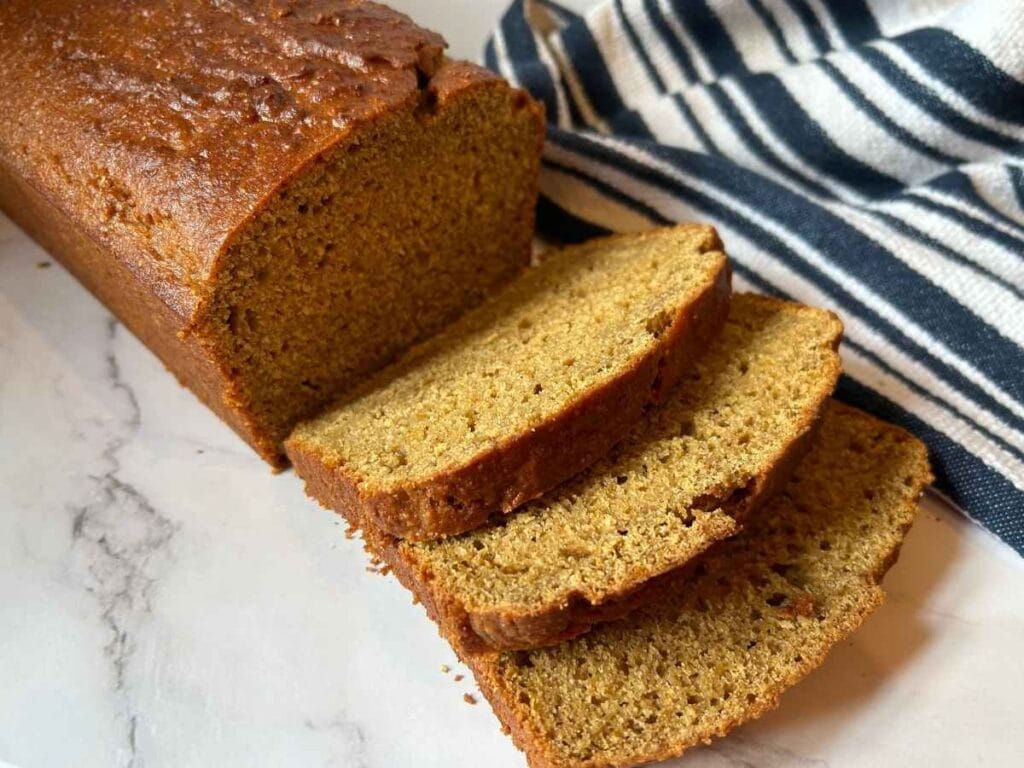 slices of sourdough discard pumpkin bread next to the rest of the loaf