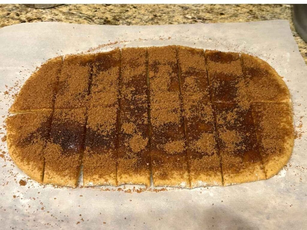 sourdough pumpkin cinnamon stick dough sliced on a parchment paper before baking