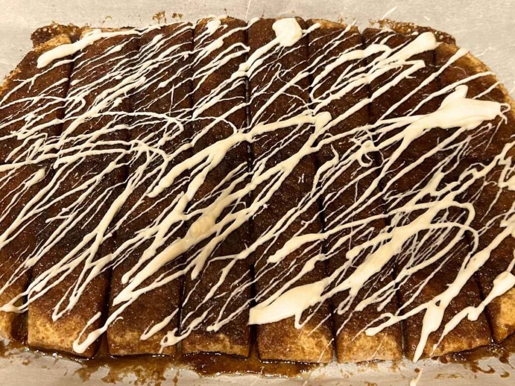 icing drizzled over cinnamon breadsticks
