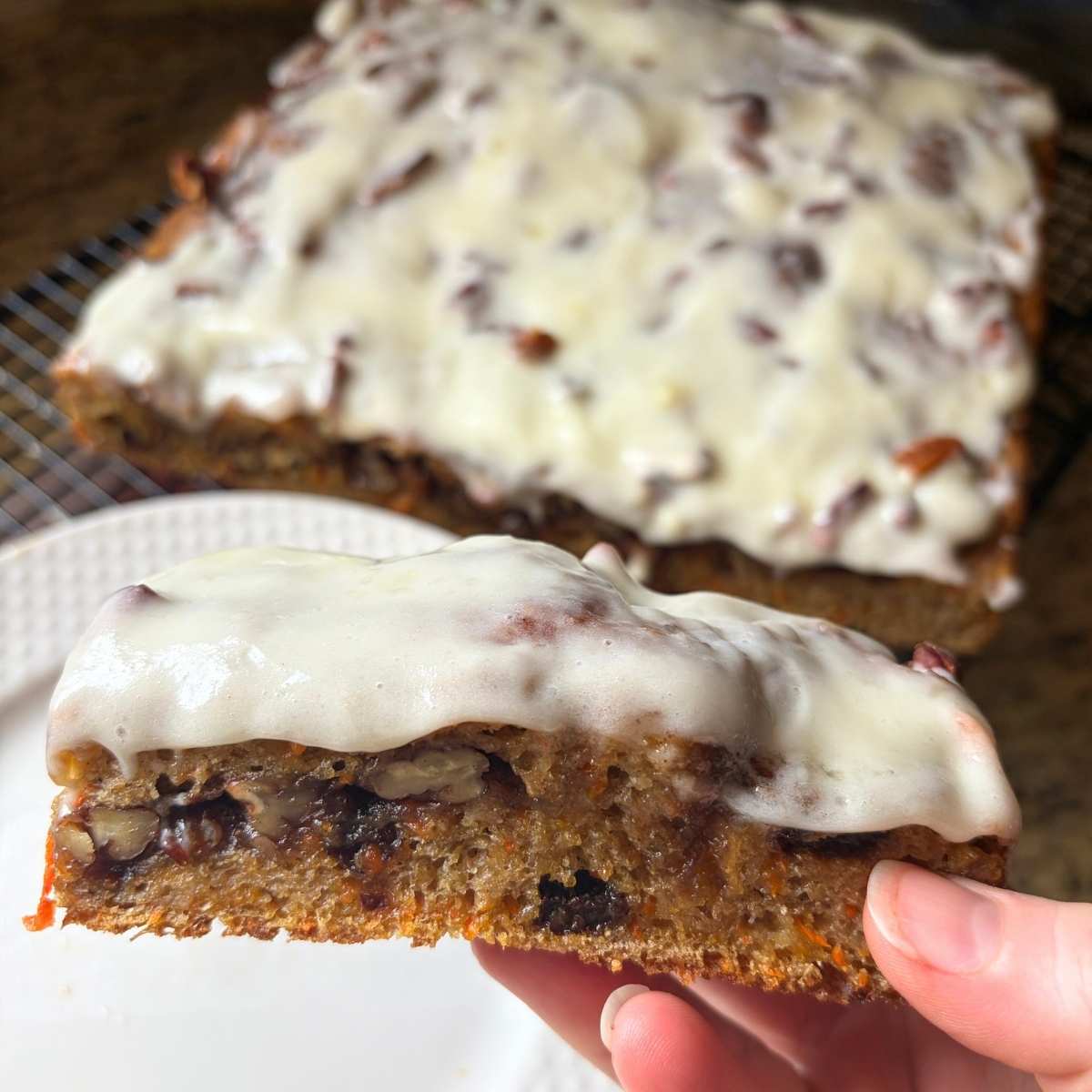 close up view of a slice of iced sourdough carrot cake focaccia