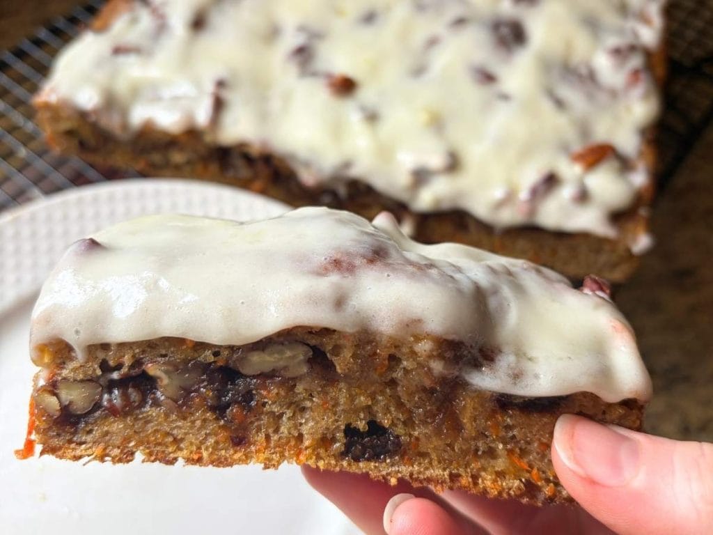 close up view of a slice of iced sourdough carrot cake focaccia
