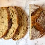 close up shot of a sourdough boule and three slices