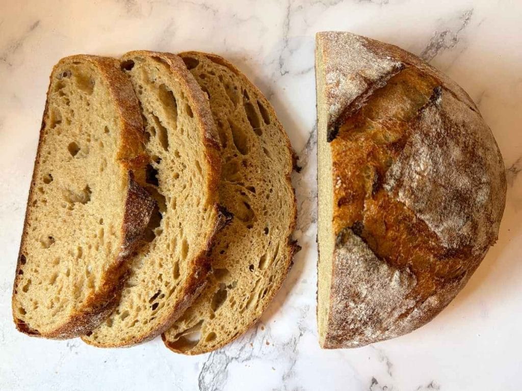 close up shot of a fresh milled flour sourdough boule and three slices