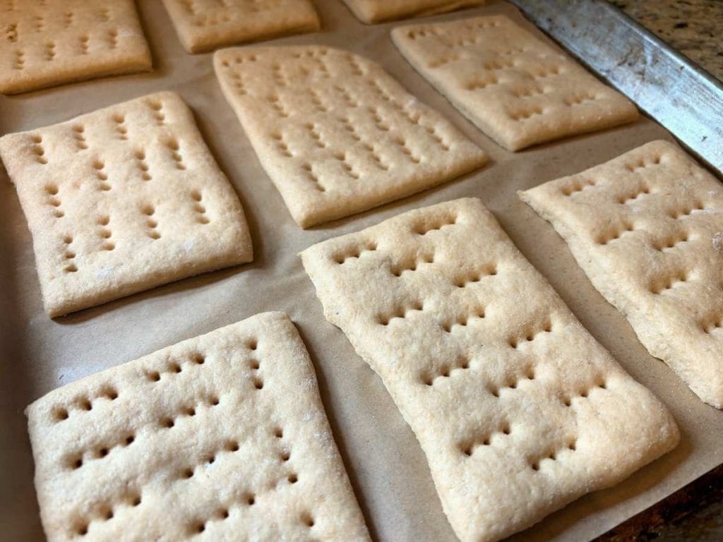 risen sandwich thins dough squares with holes poked on a parchment-lined baking sheet