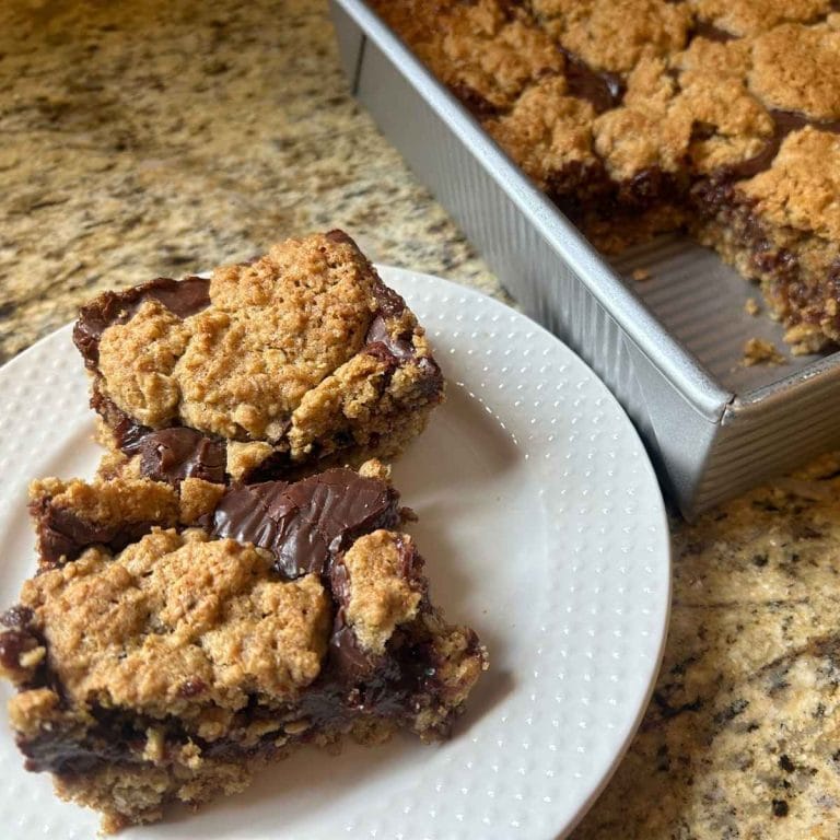 A plate of oatmeal fudge bars made with fresh‑milled flour, cut into neat squares and shown up close.