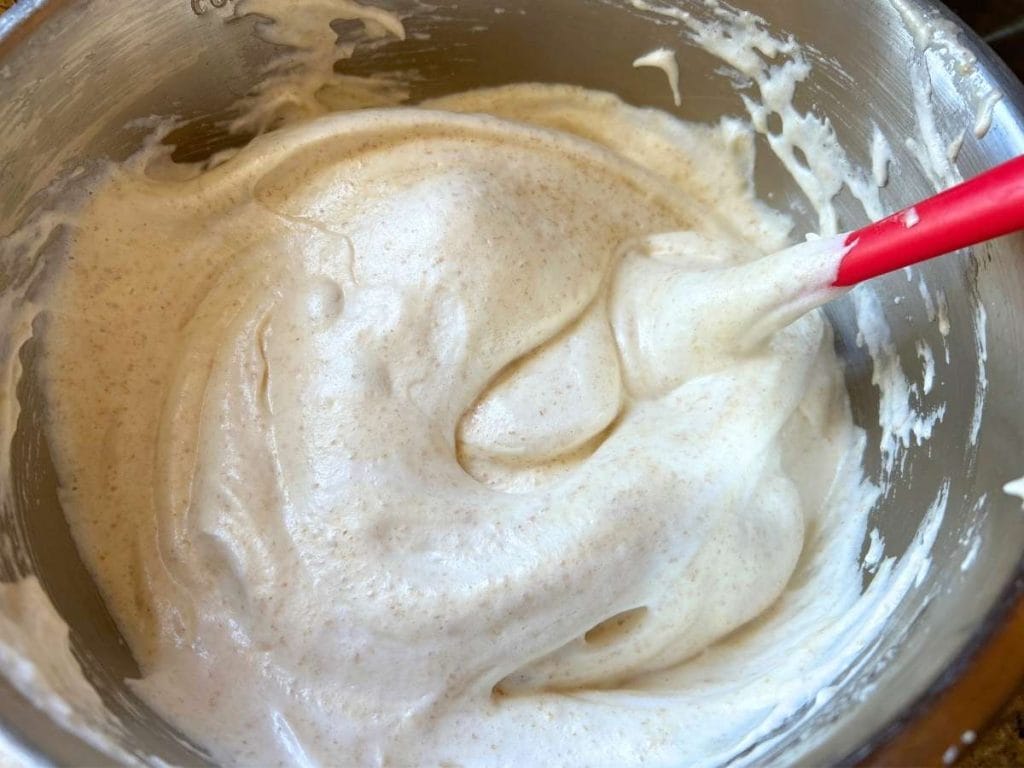 folding whipped egg whites into yolk and flour mixture for ladyfinger batter