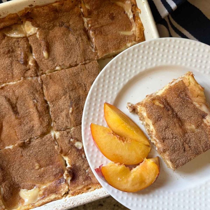 A peaches and cream cake with sliced peaches, shown in a bright, close-up overhead view