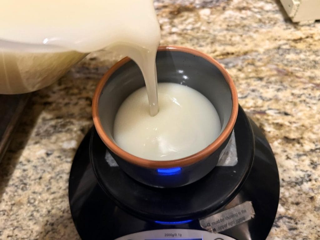 pouring soap batter into ceramic ramekins on a scale