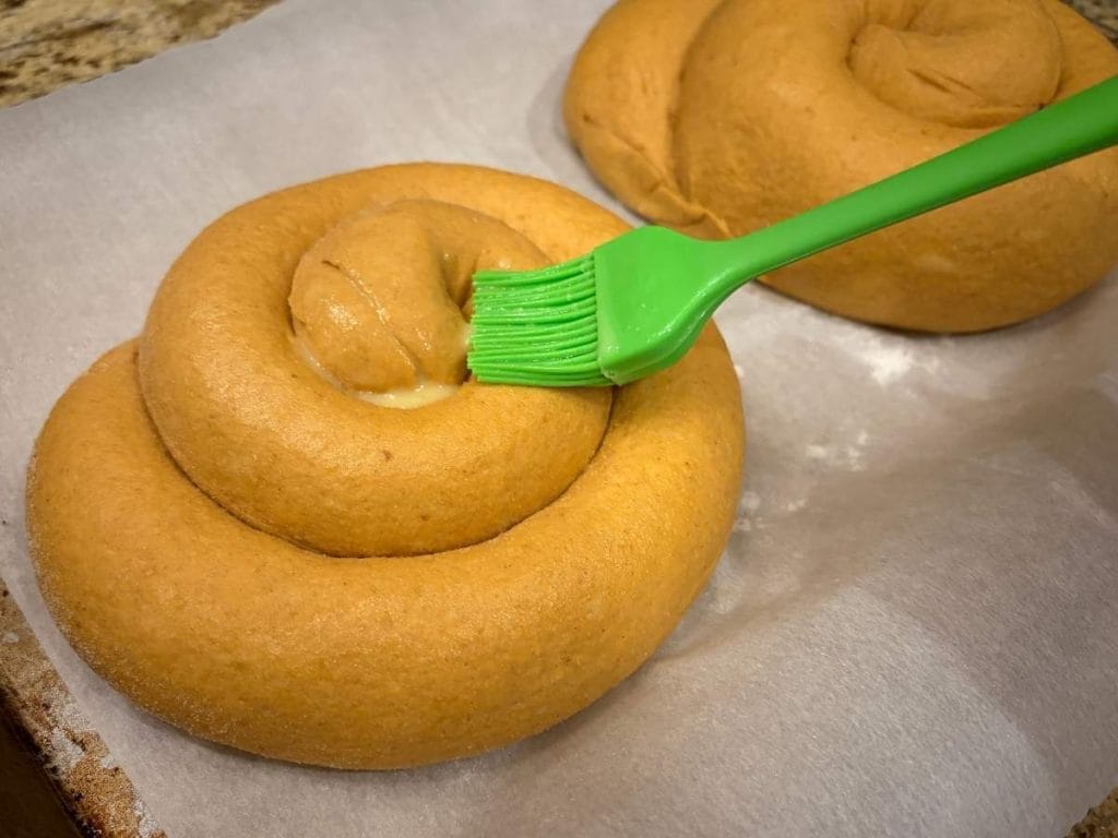 egg washing bread dough before baking