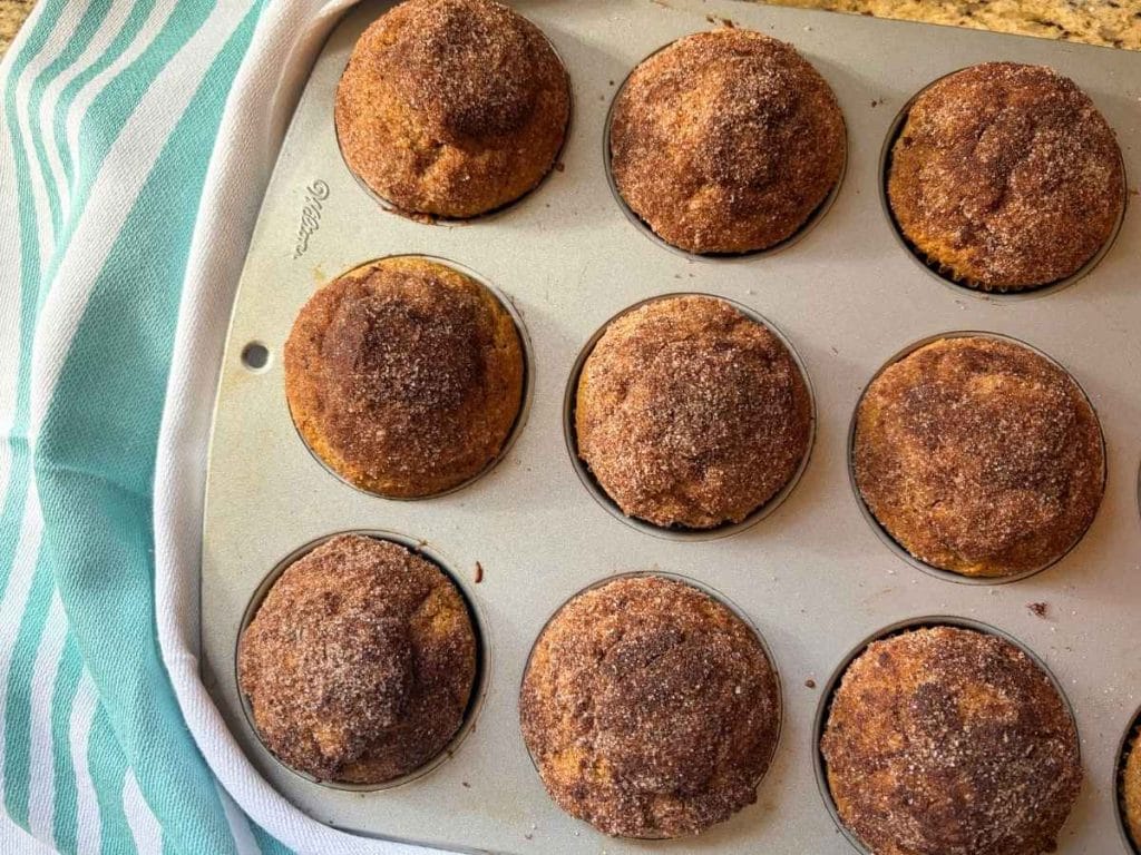 Pumpkin spice muffins baked in a muffin pan and topped with cinnamon sugar
