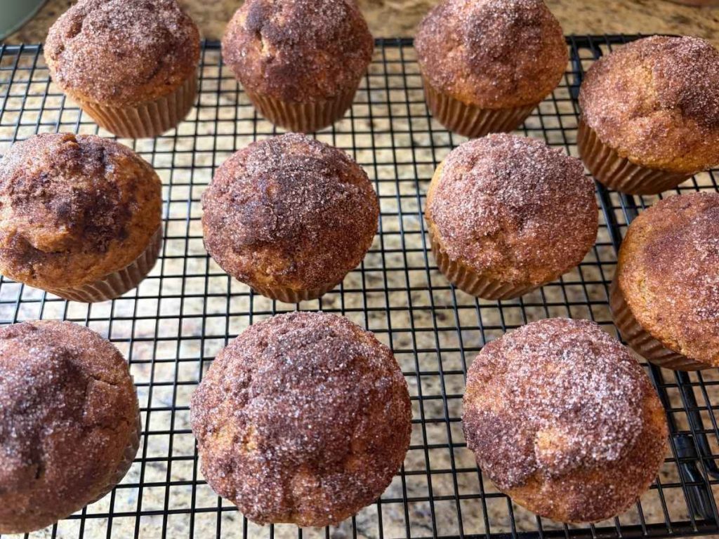pumpkin spice muffins topped with cinnamon sugar on a cooling rack