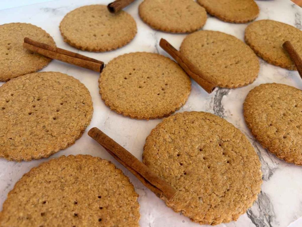 speculaas graham crackers laid out with cinnamon sticks